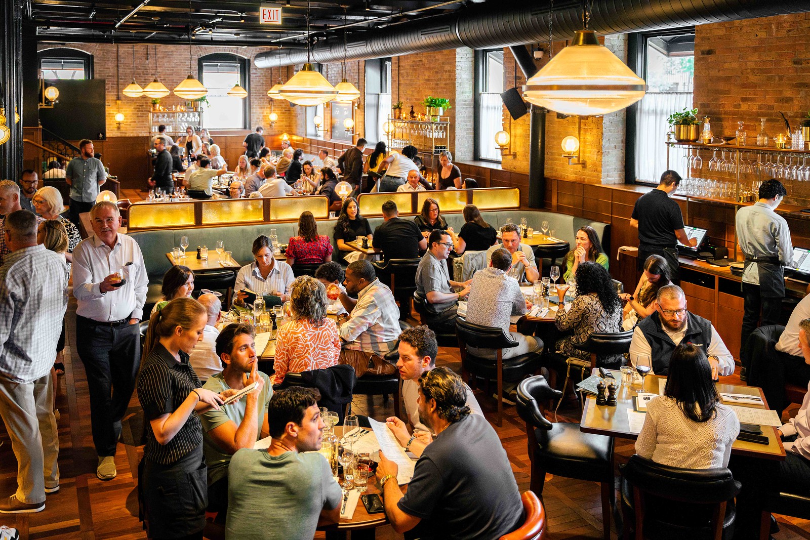 A shot of a busy service at Hawksmoor Chiacgo - the dining room filled with patrons and staff