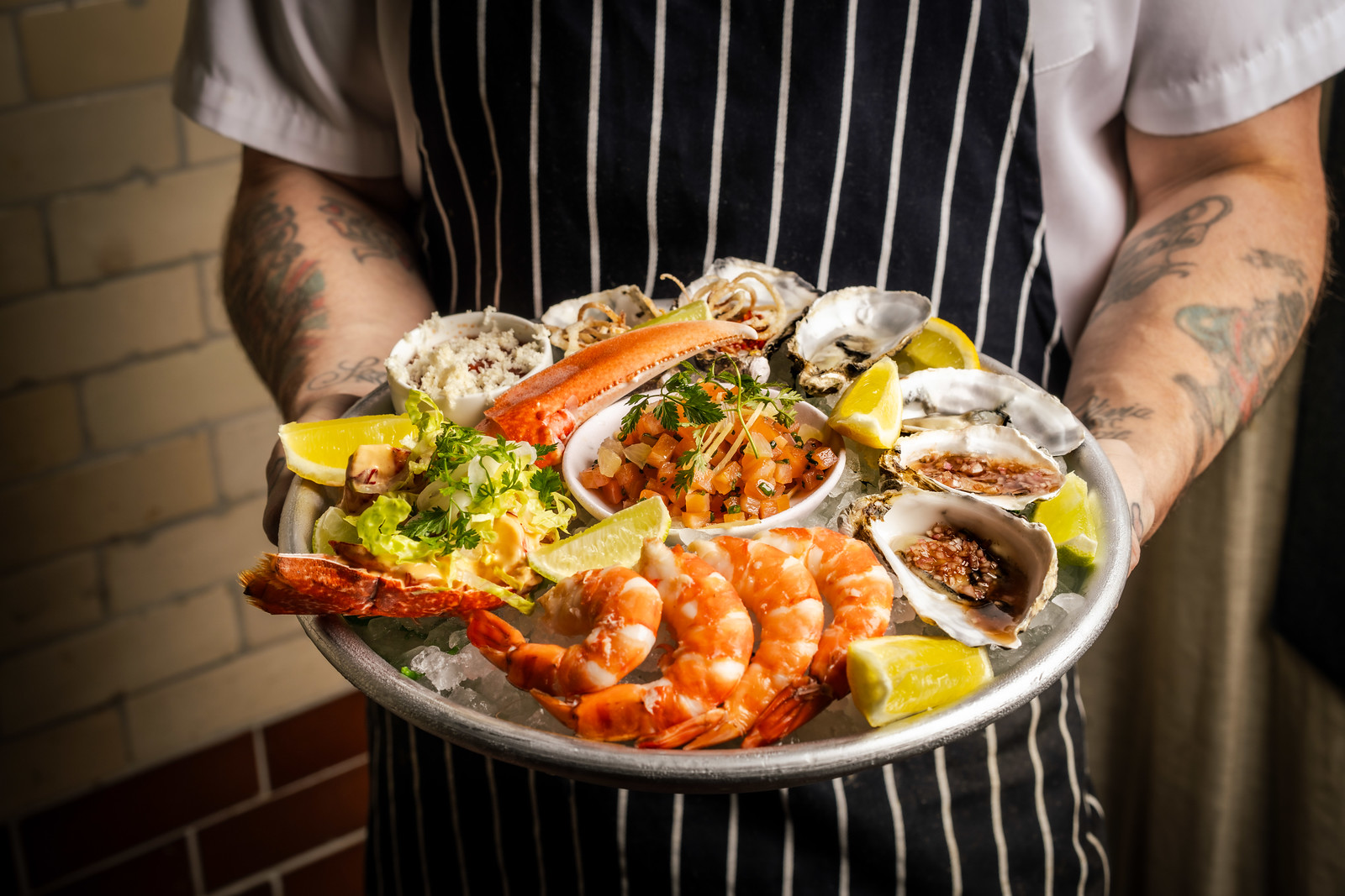 Chef carefully holding a platter of seafood