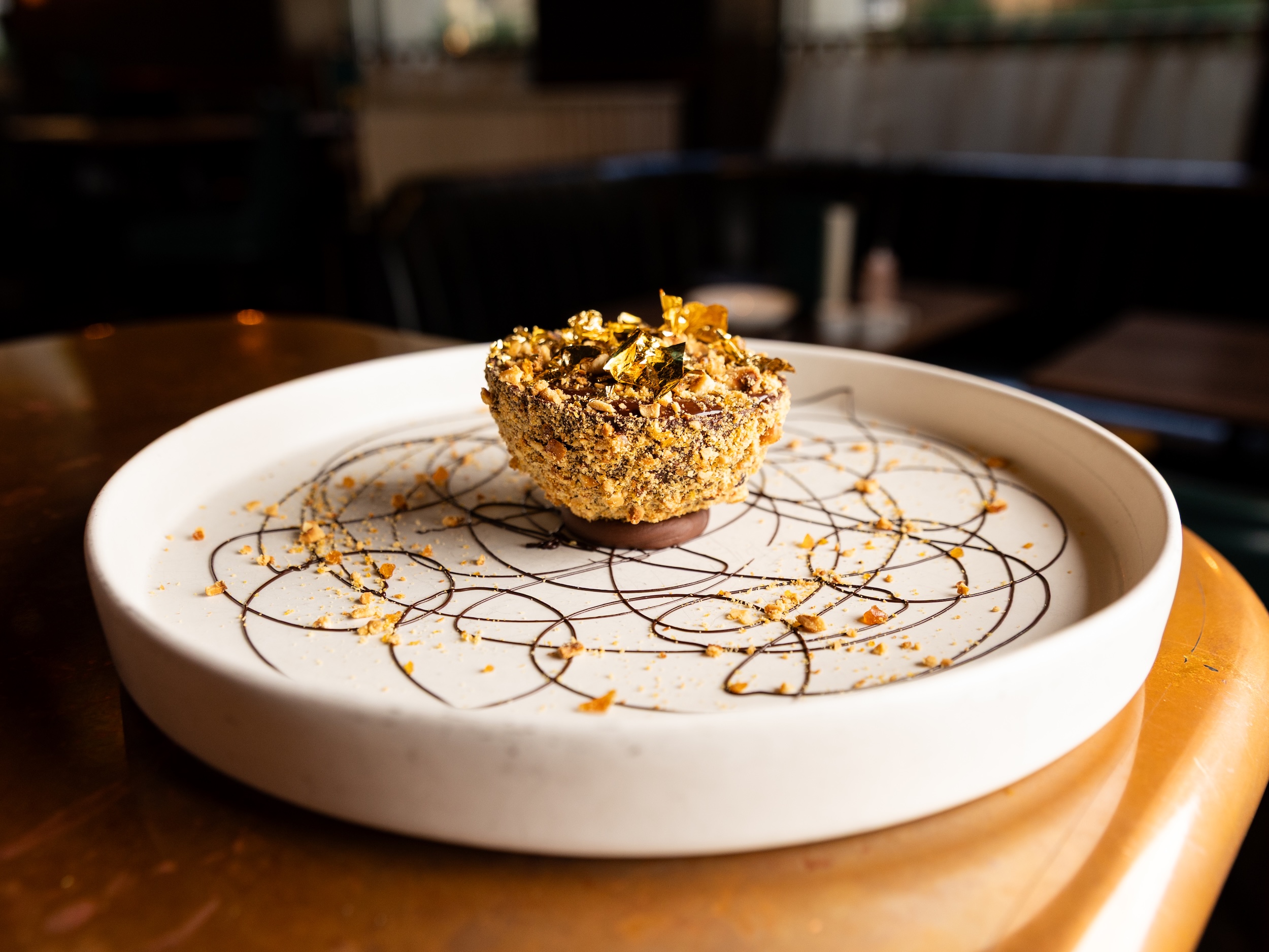 Grand Rocher Dessert at Hawksmoor served with gold leaf on a circular white plate