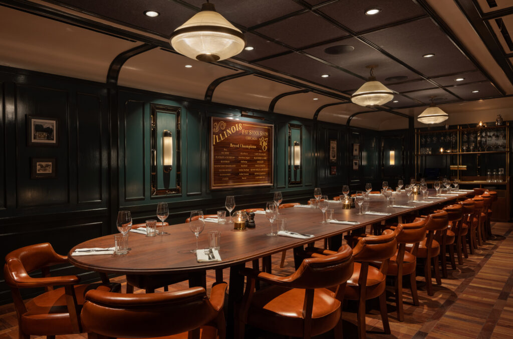 A shot of the Big Mike Private Dining room at Hawksmoor Chicago; long table in the middle of wood panelled room, surrounded by chairs