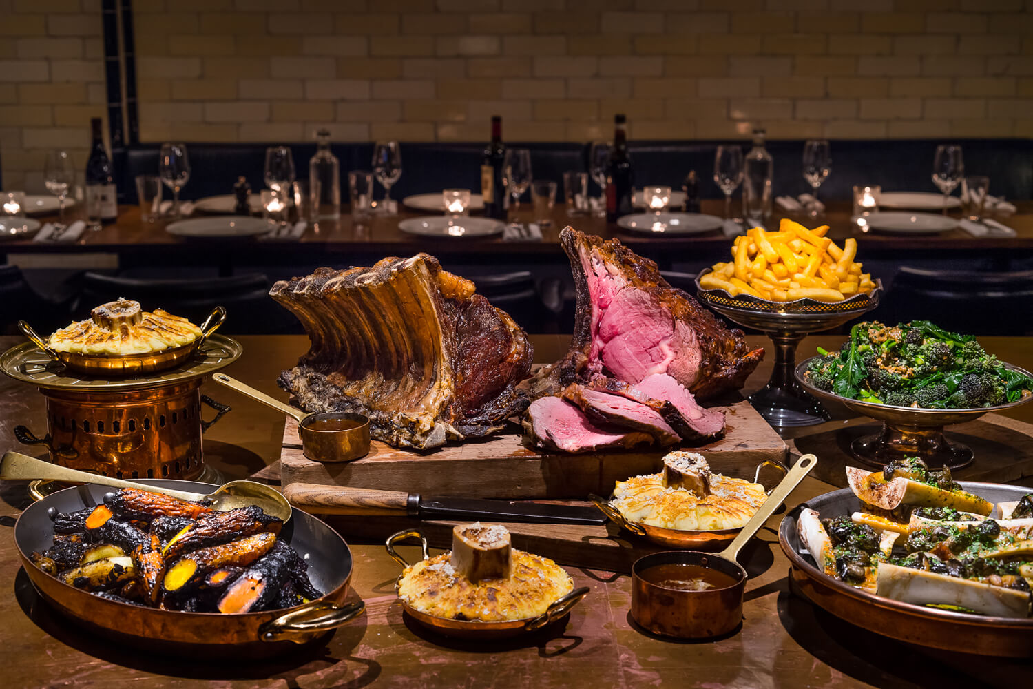 A generously laden table - large joint of meat carved, pies, starters and side dishes