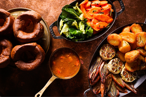 An overhead shot of the wooden table with Sunday roast trimmings