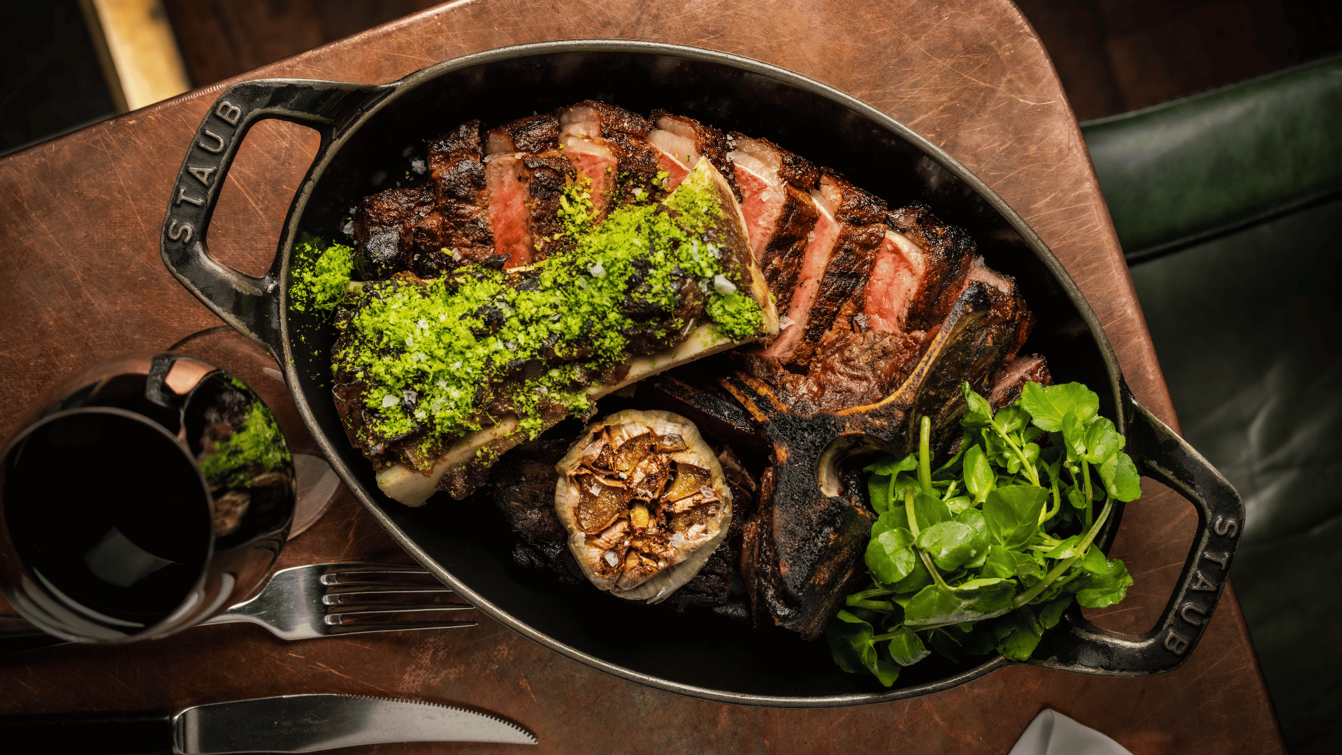 A skillet wityh a sharing Longhorn steak with bone marrow